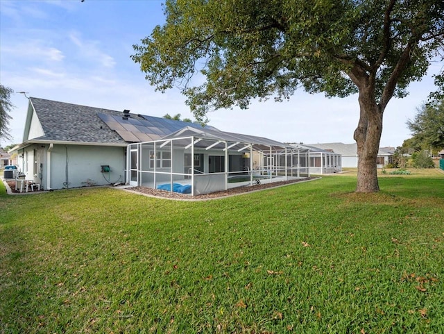 back of house featuring a lanai and a lawn