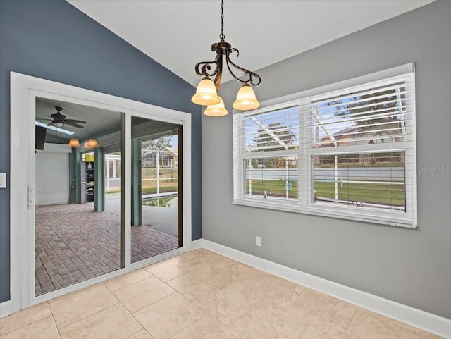 unfurnished dining area with light tile patterned floors, ceiling fan with notable chandelier, plenty of natural light, and vaulted ceiling