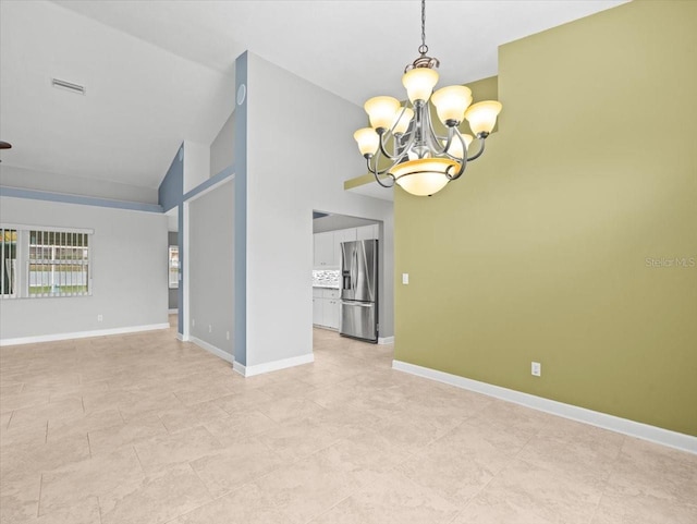 empty room featuring an inviting chandelier and lofted ceiling