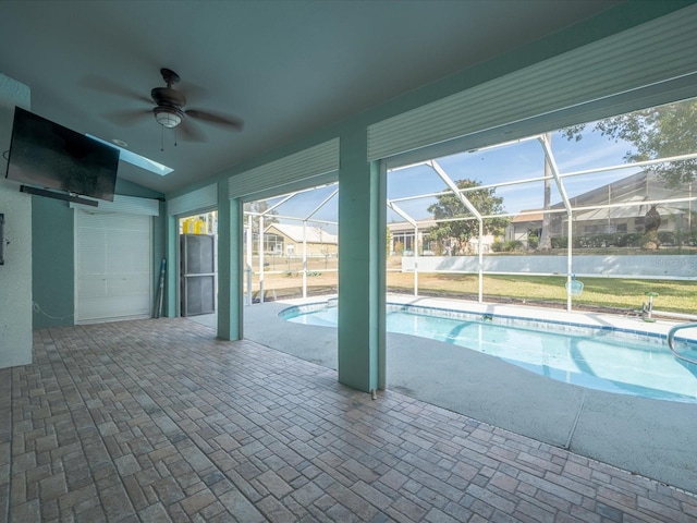 view of pool with ceiling fan, glass enclosure, and a patio