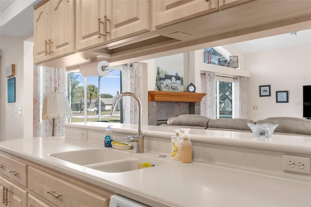 kitchen with sink, light brown cabinets, and lofted ceiling