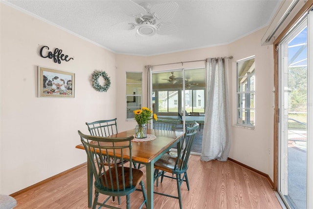 dining space with a textured ceiling, crown molding, and light hardwood / wood-style flooring