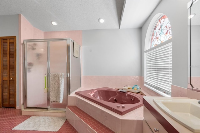 bathroom featuring a textured ceiling, tile patterned flooring, vanity, and shower with separate bathtub