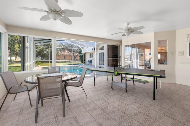 sunroom / solarium with ceiling fan and a swimming pool