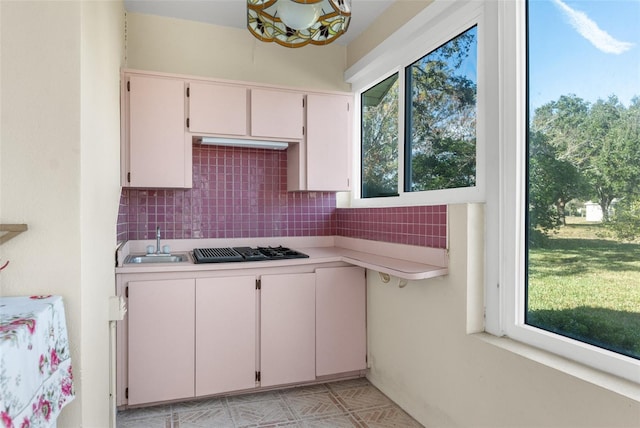 kitchen with sink, black gas cooktop, tasteful backsplash, and white cabinetry