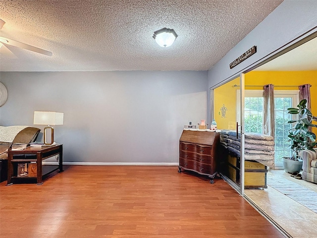 interior space with hardwood / wood-style floors, ceiling fan, and a textured ceiling