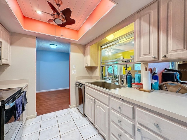 kitchen featuring black electric range, light tile patterned floors, a tray ceiling, and sink