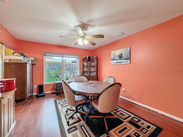 dining room featuring a textured ceiling, ceiling fan, and dark hardwood / wood-style floors