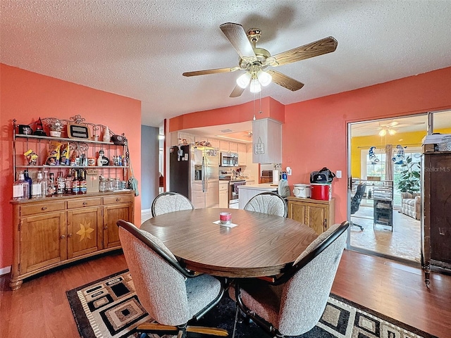 dining space with ceiling fan, light hardwood / wood-style floors, and a textured ceiling