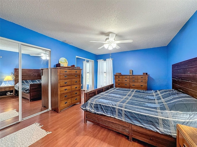 bedroom featuring hardwood / wood-style flooring, ceiling fan, a textured ceiling, and a closet