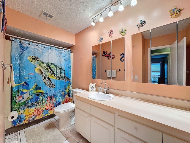 bathroom featuring a shower with curtain, vanity, a textured ceiling, tile patterned flooring, and toilet