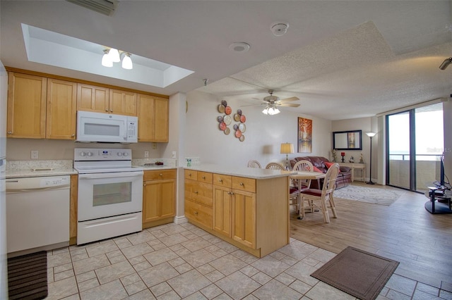 kitchen featuring kitchen peninsula, light brown cabinets, ceiling fan, light wood-type flooring, and white appliances