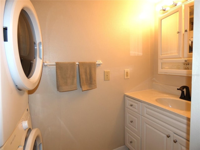 bathroom featuring toilet, stacked washer / drying machine, and vanity