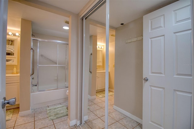 bathroom with bath / shower combo with glass door and tile patterned floors