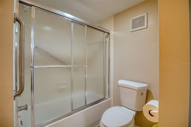 bathroom with enclosed tub / shower combo and toilet