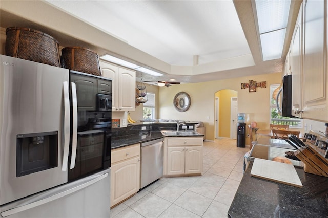 kitchen with stainless steel appliances, kitchen peninsula, light tile patterned floors, a wealth of natural light, and sink