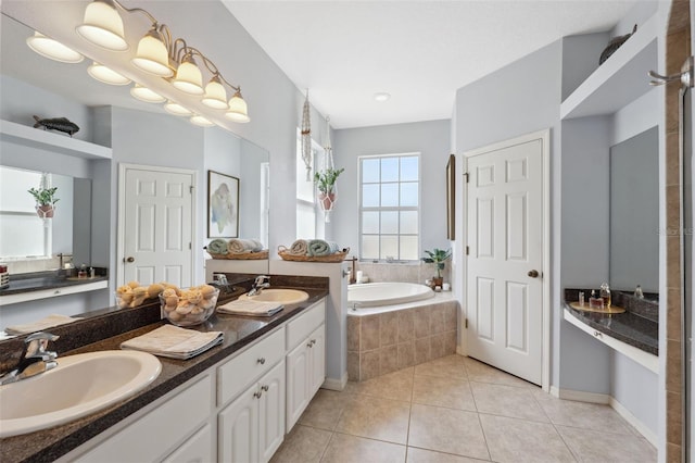 bathroom with tiled bath, tile patterned flooring, and vanity