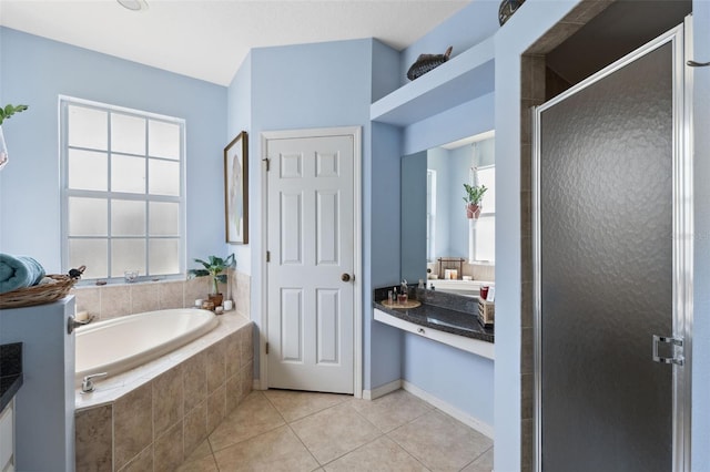 bathroom with a healthy amount of sunlight, tile patterned floors, independent shower and bath, and vanity