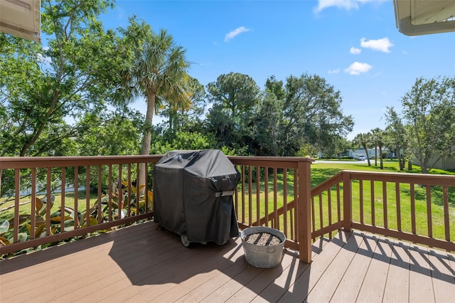 wooden terrace with a lawn and grilling area