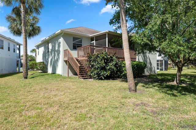 rear view of property with a yard and a wooden deck