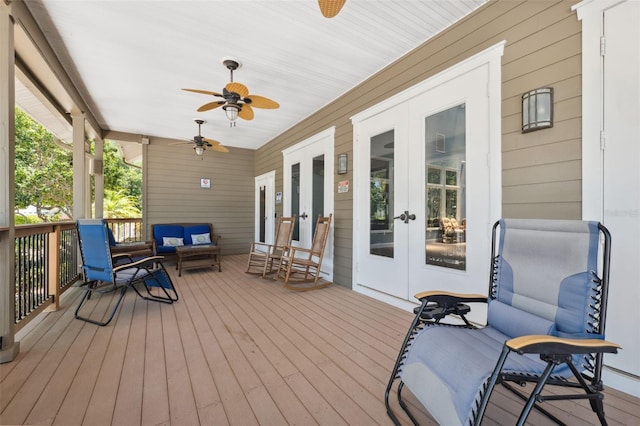 wooden terrace featuring french doors, covered porch, ceiling fan, and an outdoor hangout area