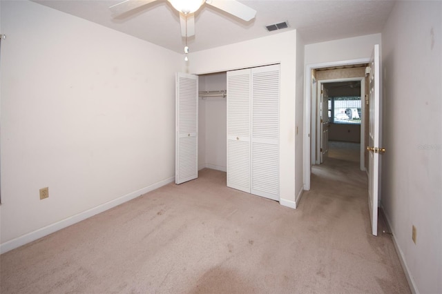 unfurnished bedroom featuring light colored carpet, a closet, and ceiling fan