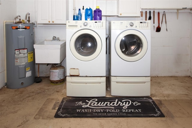 laundry area with separate washer and dryer, water heater, sink, and cabinets