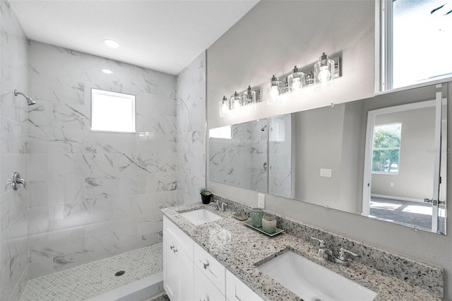 bathroom with vanity and a tile shower