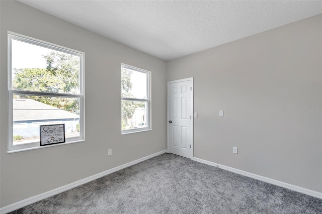 carpeted spare room featuring a textured ceiling