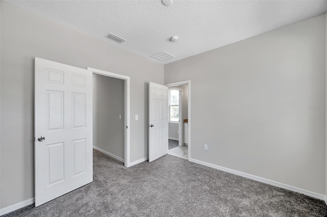 unfurnished bedroom with carpet and a textured ceiling