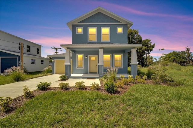 view of front facade with a lawn, a garage, and covered porch