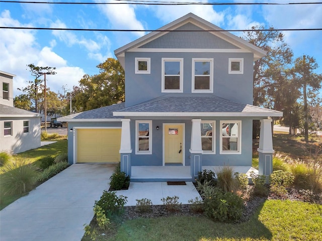 view of front of home featuring a porch, a garage, and a front yard