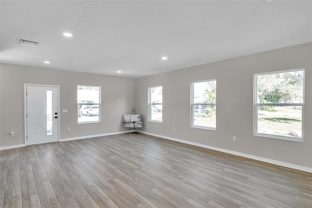 unfurnished room featuring plenty of natural light and light wood-type flooring