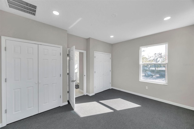 unfurnished bedroom with dark carpet