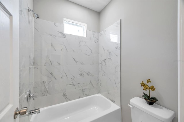 bathroom featuring toilet and tiled shower / bath