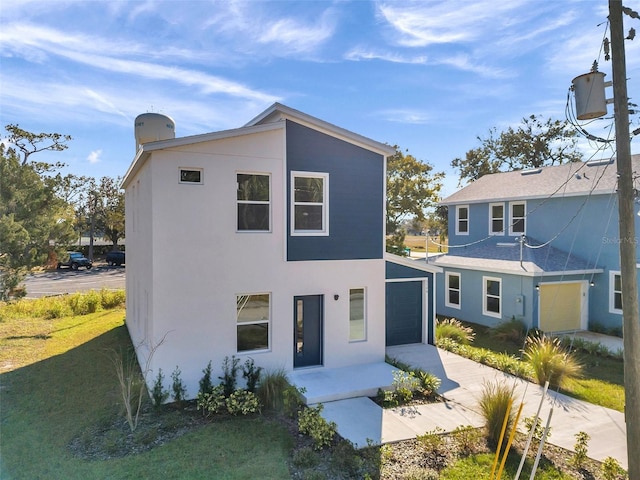 view of front of property featuring a garage and a front lawn