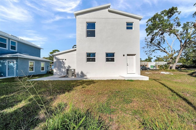 back of property with a patio, central AC, and a lawn