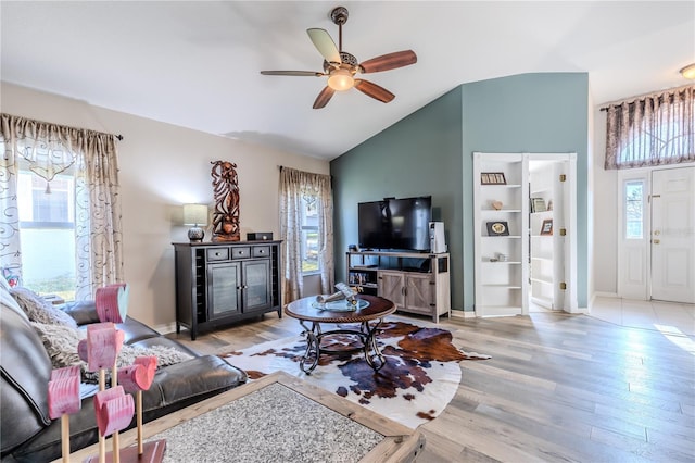 living room with ceiling fan, lofted ceiling, and light hardwood / wood-style flooring