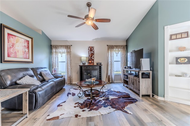 living room featuring ceiling fan, lofted ceiling, and light hardwood / wood-style floors