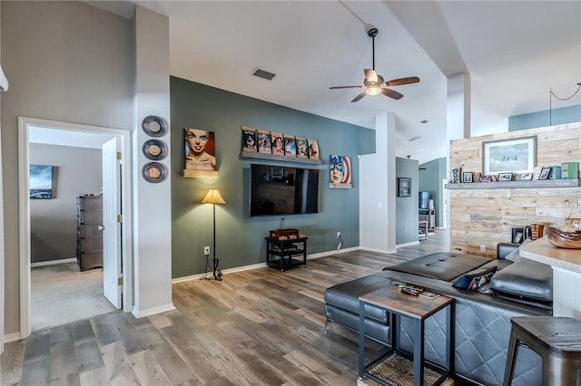 living room featuring ceiling fan, lofted ceiling, and wood-type flooring