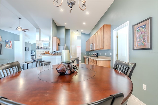 dining space featuring lofted ceiling and ceiling fan with notable chandelier