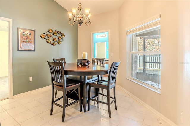 dining space with lofted ceiling, light tile patterned floors, and a chandelier