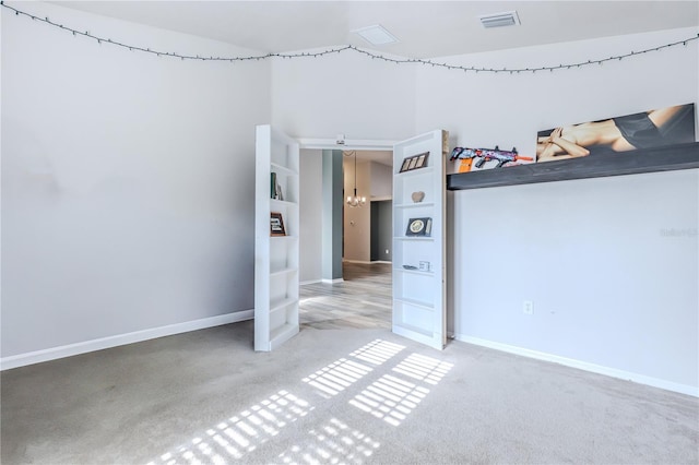 unfurnished bedroom with carpet and a chandelier