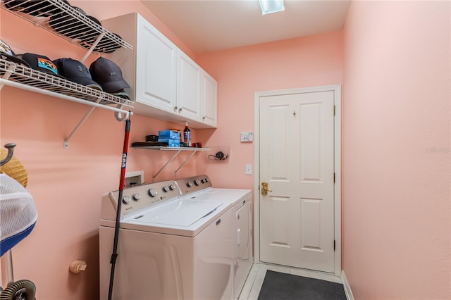 laundry room featuring washing machine and dryer, cabinets, and light tile patterned floors