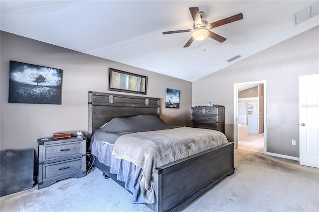 bedroom with ceiling fan, light colored carpet, ensuite bathroom, and lofted ceiling