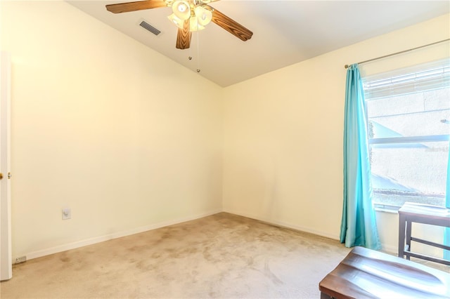 empty room with lofted ceiling, light colored carpet, and ceiling fan