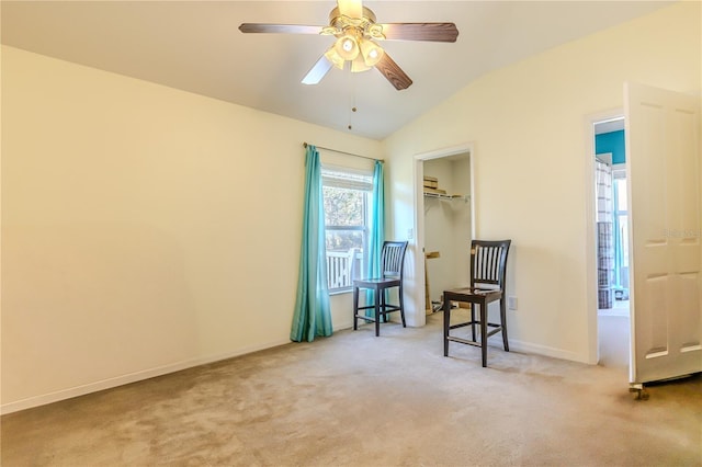 sitting room with ceiling fan, vaulted ceiling, and carpet flooring