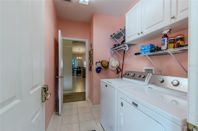 washroom with light tile patterned floors, independent washer and dryer, an inviting chandelier, and cabinets