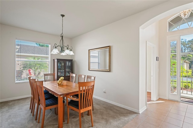 tiled dining area featuring a chandelier