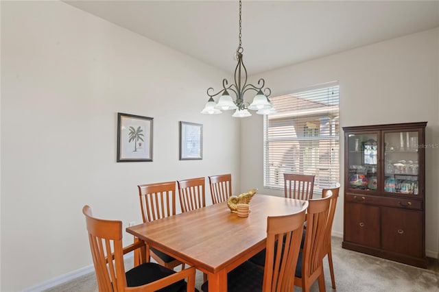 dining room featuring light colored carpet and an inviting chandelier